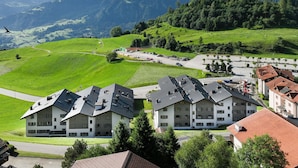 A residential area with modern houses, a road, and a mountainous backdrop. - La Siala Apt.54 by Interhome (Falera)