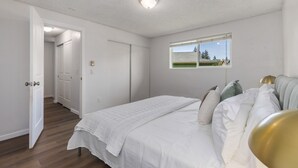 A bedroom with a bed, a window, and a door leading to another room. - Comfortable Townhouse in Ash Way Lynnwood (Lynnwood)
