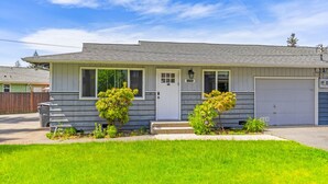 A single-story house with a gray exterior, a white front door, and a garage. - Comfortable Townhouse in Ash Way Lynnwood (Lynnwood)