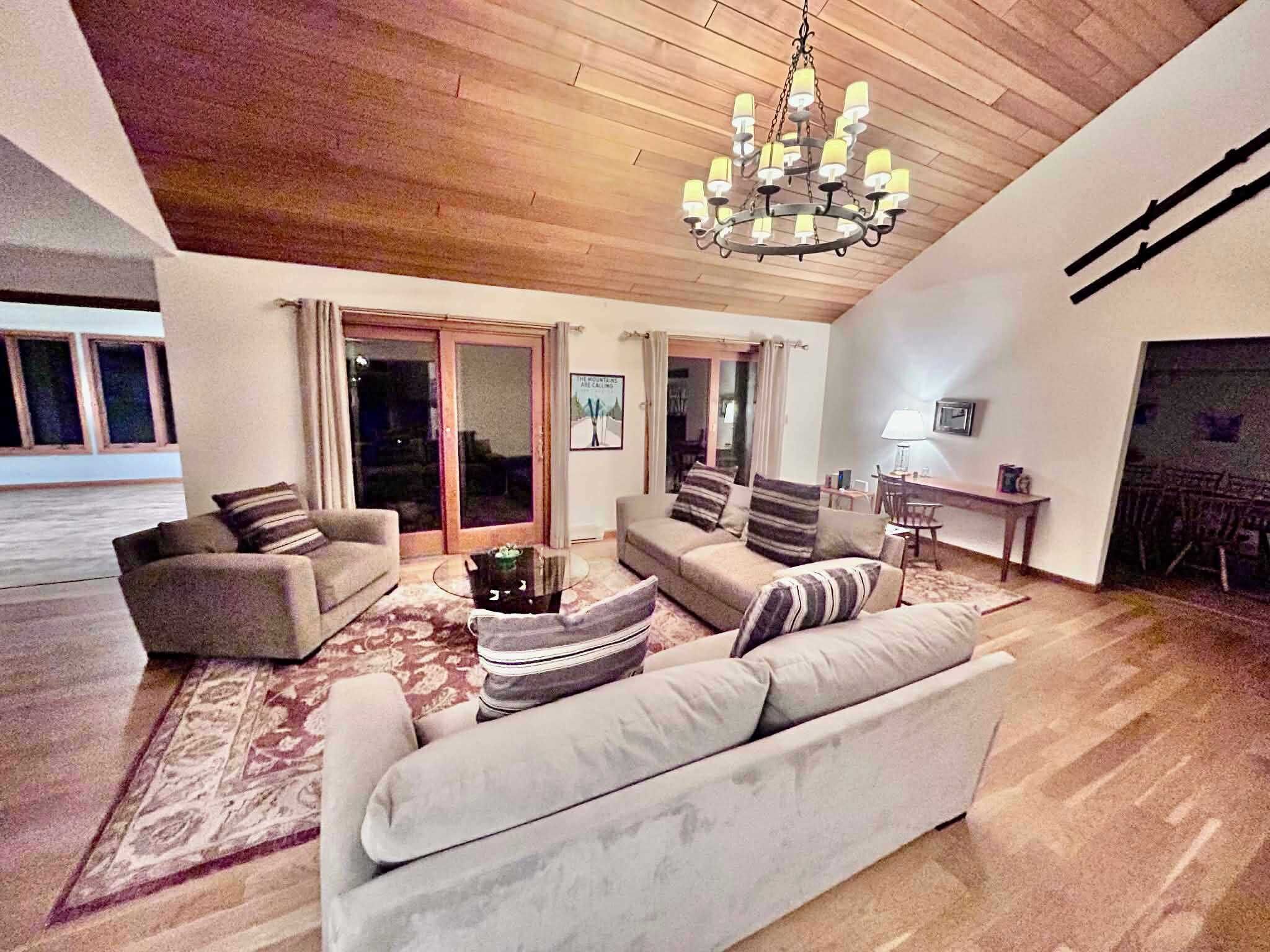 The Great Room featuring Red Cedar Cathedral ceilings, slider access to the expansive deck, pocket wet bar, and gas fireplace.  