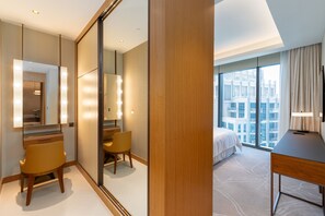 A hotel room with a large mirror, a bed, a desk, and a chair. - Address Dubai Opera 2BR | Walk to Mall, Burj Khalifa & Opera (Dubai)