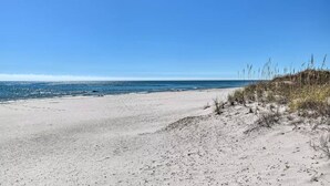 En sandstrand med en klarblå himmel och ett hav.
