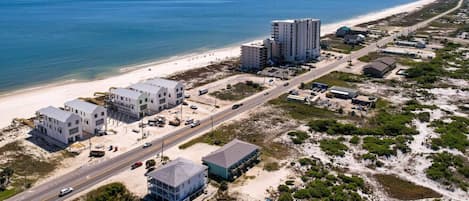 Vista aérea de una zona costera con playa, edificios y una carretera.