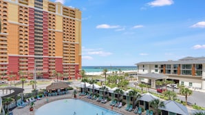 Un hotel con zona de piscina, vista al mar y un muelle al fondo.