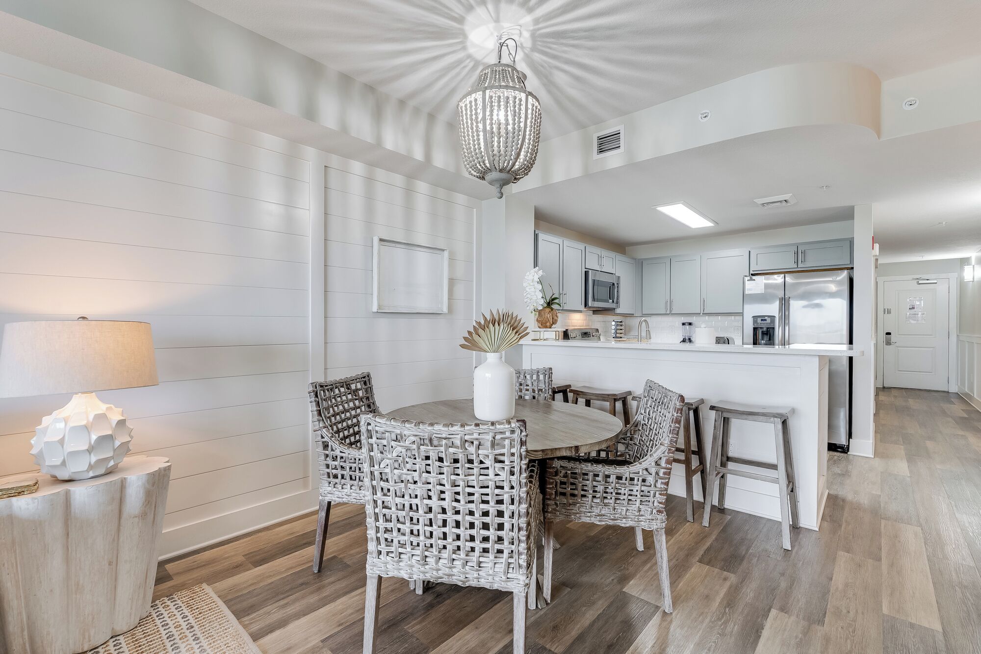 A modern kitchen with white cabinetry, a central island, and stainless steel appliances.
