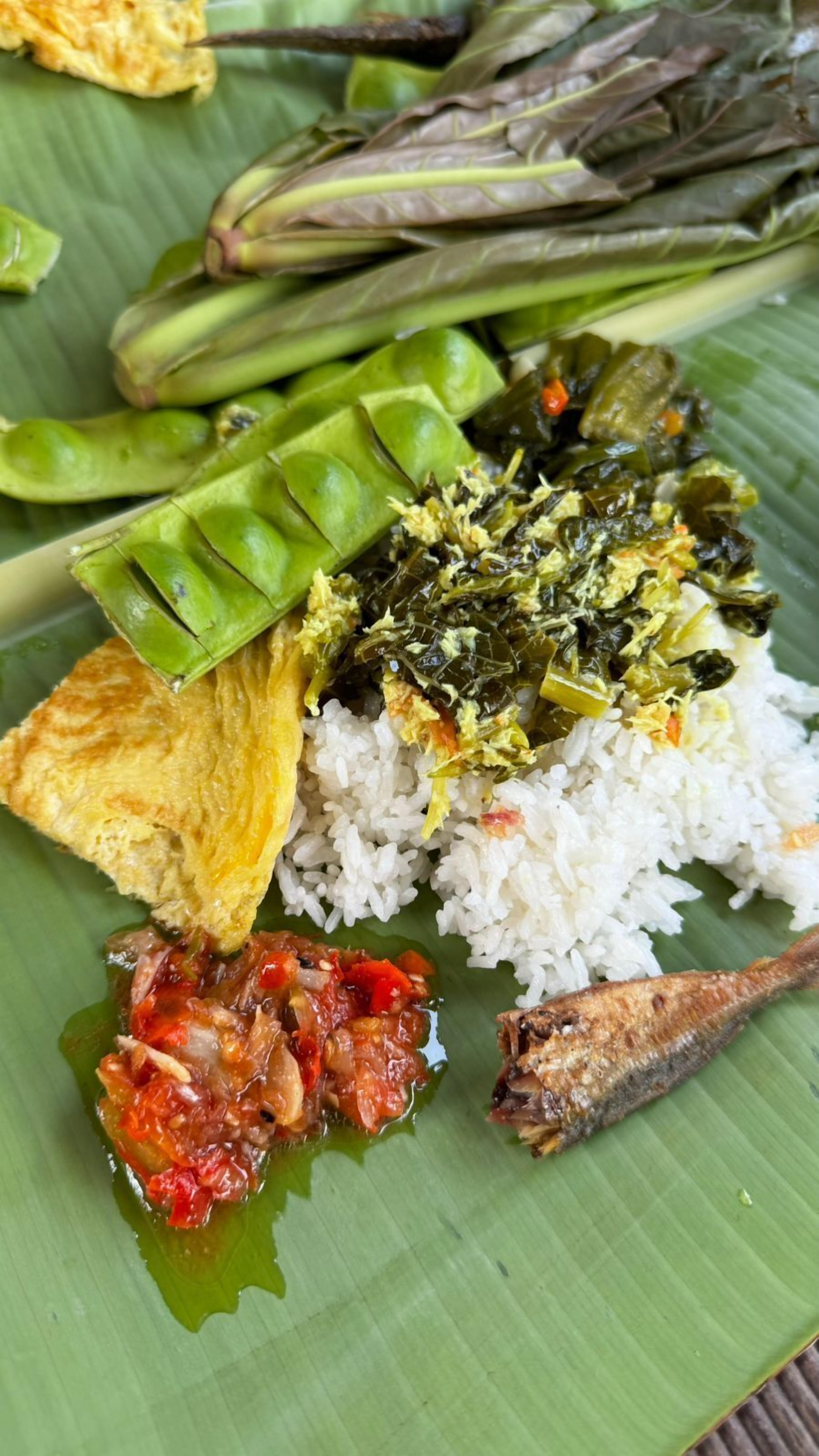 A plate of food with rice, green beans, a fried fish, and a red sauce.