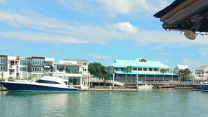 A marina with several boats docked, a building with a blue roof, and a waterfront view.