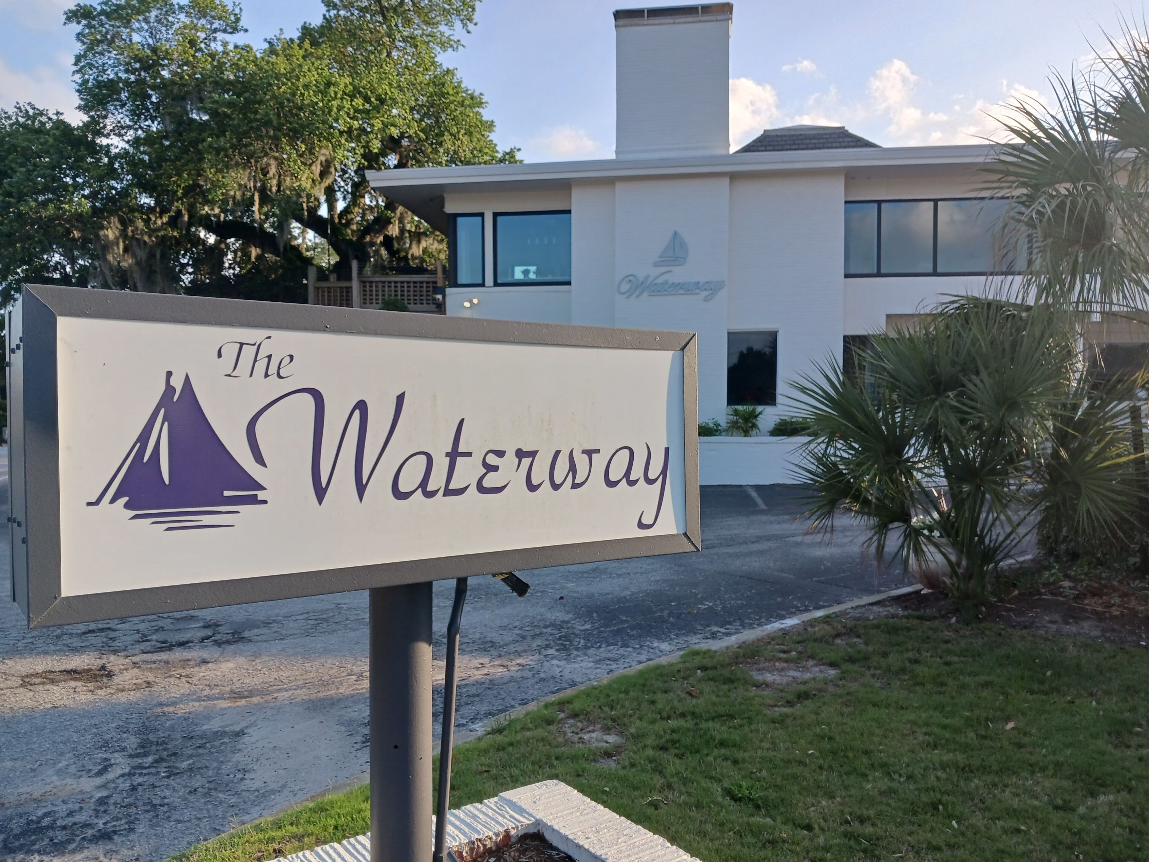 Skilt for 'The Waterway' med logo af sejlbåd.