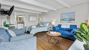 A modern living room with a bed, blue sofa, and a coffee table.