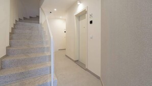 A staircase leading to a landing with a door marked 'B' and a light switch on the wall.