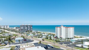Un hôtel situé sur la côte, avec plusieurs étages, un parking et une vue sur la plage et l’océan.