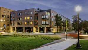 A multi-story building with a modern architectural design, featuring a mix of brick and glass facades.