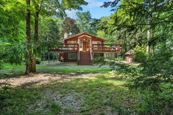 A cabin with a wooden exterior, a front porch, and a staircase leading to a deck. - Ski Chalet. EV Charger Sauna,Hot Tub,Movie Room & Firepit. PET Friendly (Blakeslee)