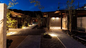 A modern house with a paved driveway, a garage, and a well-lit exterior. - Kaigyokutei-Megumi- (Sakaiminato)