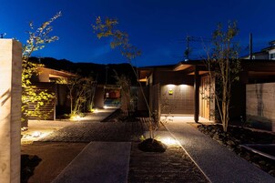 Una casa moderna con entrada pavimentada, garaje e iluminación exterior.