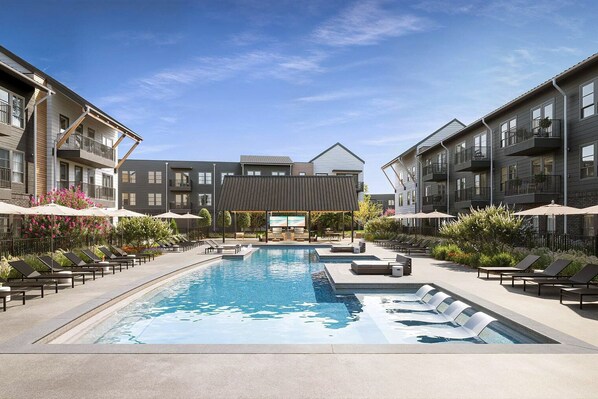 Relax by the central pool surrounded by lounge areas and comfortable seating.