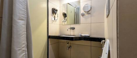 A bathroom with a toilet, sink, and mirror.
