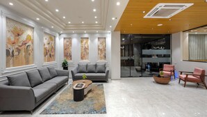 A modern living room with a grey sofa, a coffee table, and a pink armchair. - Prarambh By Siara (Nadiad)