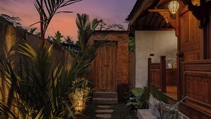 Una casa tradicional de madera con una escalera de piedra que lleva a una puerta de madera.