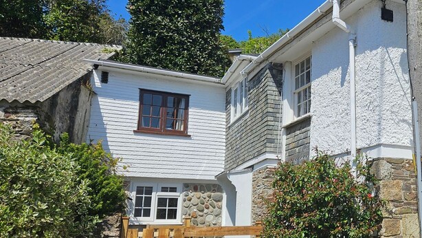 A traditional stone house with a wooden gate, white exterior walls, and a stone chimney. - Myrtle Cottage - sleeps 4 guests  in 2 bedrooms (St Mawes)