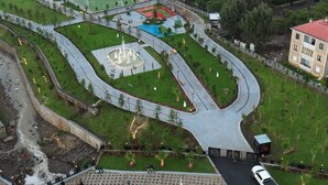 Un parking rempli de voitures, avec un grand bâtiment en arrière-plan.