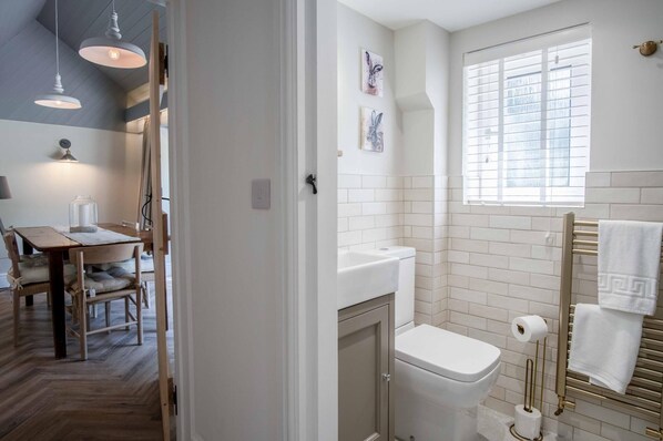 A bathroom with a toilet, sink, and towel rack.