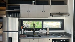 Una cocina moderna con estufa integrada, horno y refrigerador de acero inoxidable.