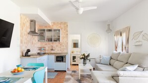 Une cuisine moderne avec un coin repas, un canapé blanc et un mur décoratif.