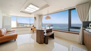 A modern living room with a large window offering a view of the sea. - Donghae Il Mare Pension (Donghae)