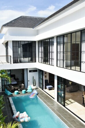 A modern two-story house with a swimming pool, large windows, and outdoor seating areas. - The W House, Luxury Villa 5 minutes from the beach (Bali)