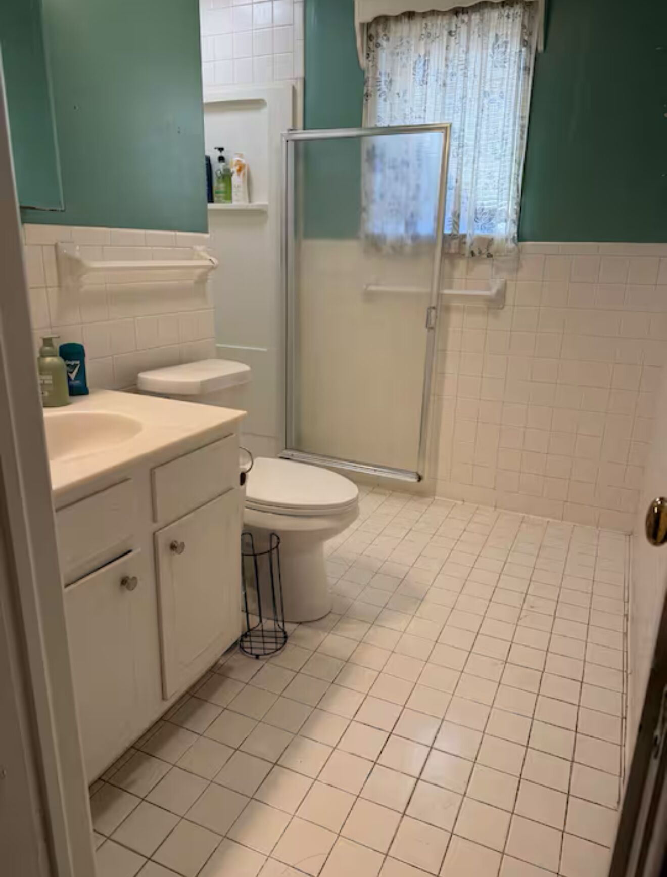 Un bagno con il water, lavandino e doccia.