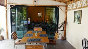 A dining area with a table, chairs, and a vase with flowers. - Villa Manni, bright and welcoming, nestled among coconut trees (Koh Phangan)