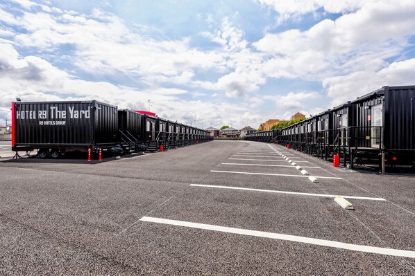 A parking lot with rows of black containers labeled "HOTEL R9 The Yard" and "RS HITS GROUP." - HOTEL R9 The Yard Mokaaramachi (Mooka)