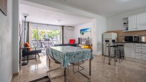 Une cuisine spacieuse avec un coin repas, un balcon et une vue sur l’extérieur.