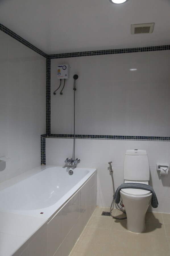 Un baño con bañera, inodoro y cabina de ducha.