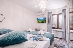 Une chambre d’hôtel équipée d’un lit, d’un bureau, d’une télévision et offrant une vue sur l’extérieur.