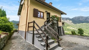 A house with a stone staircase, a door, and a window with a shutter. - Casa Clelia Centovalli with Private Garden, Moneto, Switzerland (Moneto)