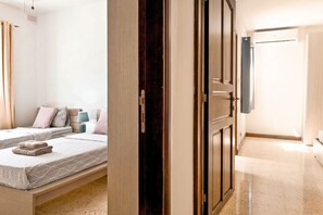 A hotel room with a bed, a bedside table, a lamp, and a wardrobe.