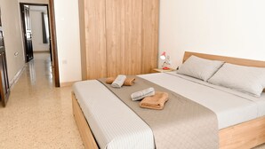 Un dormitorio ordenado con una cama, una mesita de noche y una lámpara.