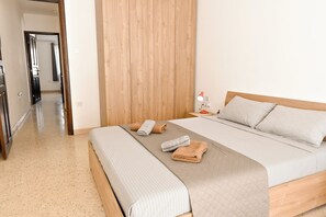 A neatly arranged bedroom with a bed, bedside table, and a lamp.