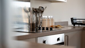 Una cocina con electrodomésticos de acero inoxidable, utensilios de cocina y un panero.