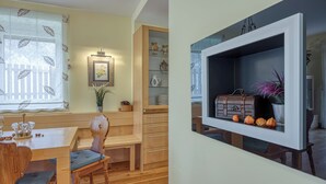 A dining area with a wooden table and chairs, a bench, and a cabinet with glass doors.