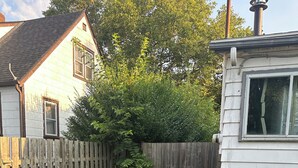 A backyard with a wooden fence, a small shed, and an air conditioning unit. - Point peele (Leamington)