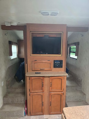 A compact kitchenette with a built-in oven, microwave, and a small countertop. - RV Bunkhouse on the River (Mason City)
