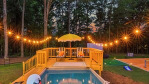 A swimming pool with a wooden deck, swan floaties, and a deck chair. - Near AtL, Pickleball, Golf, Pool, Karaoke, Tikibar, 1.25 Acre Private Retreat (Locust Grove)
