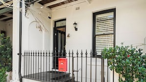 A white building with a black gate, a red mailbox, and a number 24 sign. - Stylish 3BR, 2BA King Beds Balmain Terrace Near Parks, Ferries & Darling Street (Balmain)