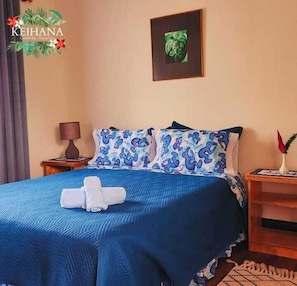 Una habitación de hotel con una cama, una mesita de noche, una lámpara y un cuadro en la pared.