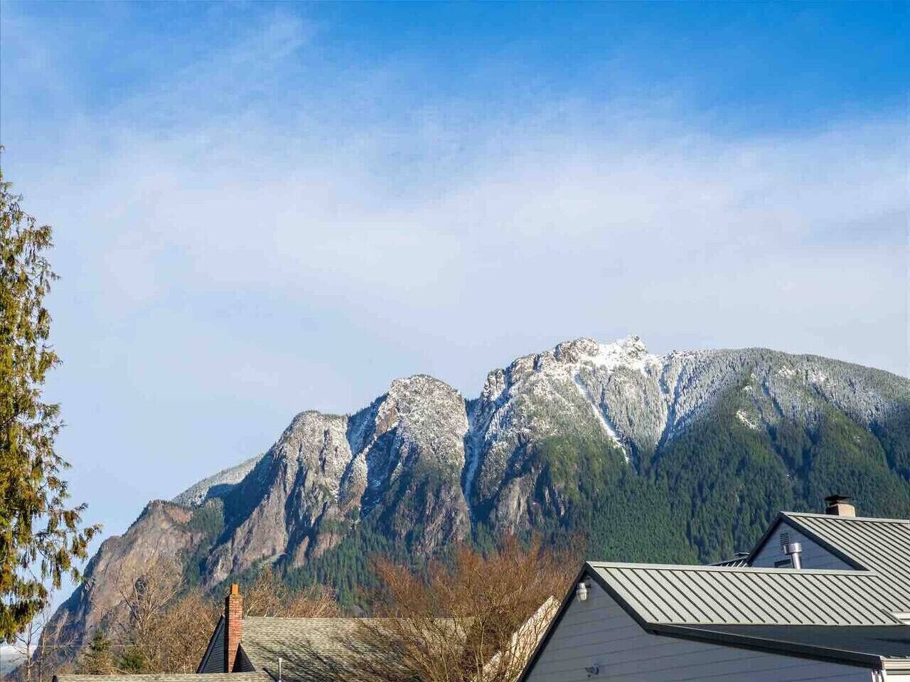 Un paisaje montañoso con una casa en primer plano.