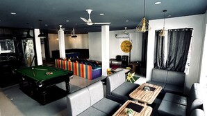 A modern lounge area with a pool table, comfortable seating, and ambient lighting. - Moustache Hostel Rishikesh (Rishikesh)