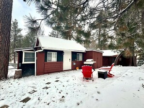 Relax in a cozy cabin surrounded by tall pine trees.